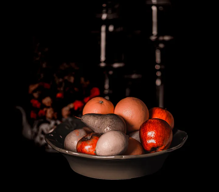 Bowl of fruit in monochrome with red and orange highlights