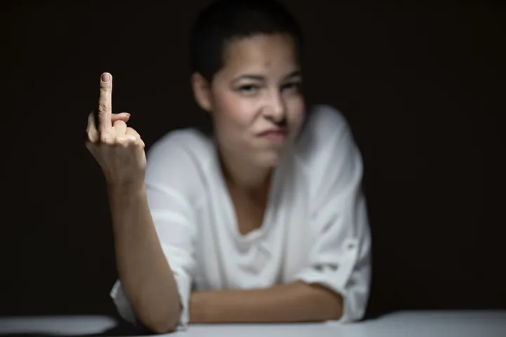 An angry woman giving the finger (middle finger)