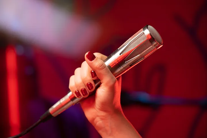 Close up of woman's hand holding a microphone.