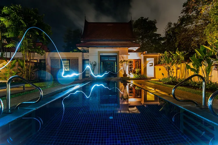 Blue lightning shooting across a pool into a house