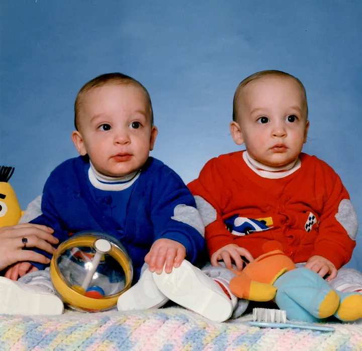 Twin infants dressed in blue and red