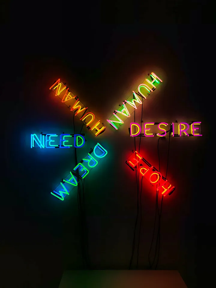 Neon sign with words human, desire, need, dream, and hope