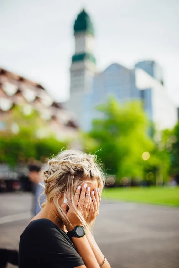 Anguished woman holding her hands to her face