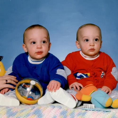 Twin infants dressed in blue and red
