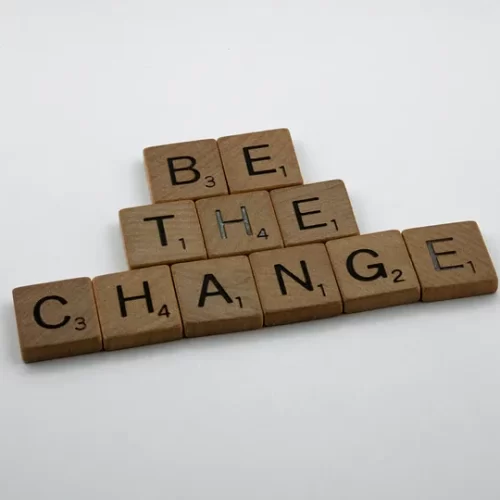 Scrabble letter tiles spelling "be the change."